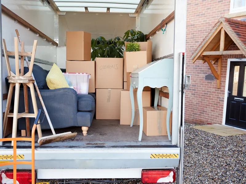 A removals van loaded with furniture and boxes at the door